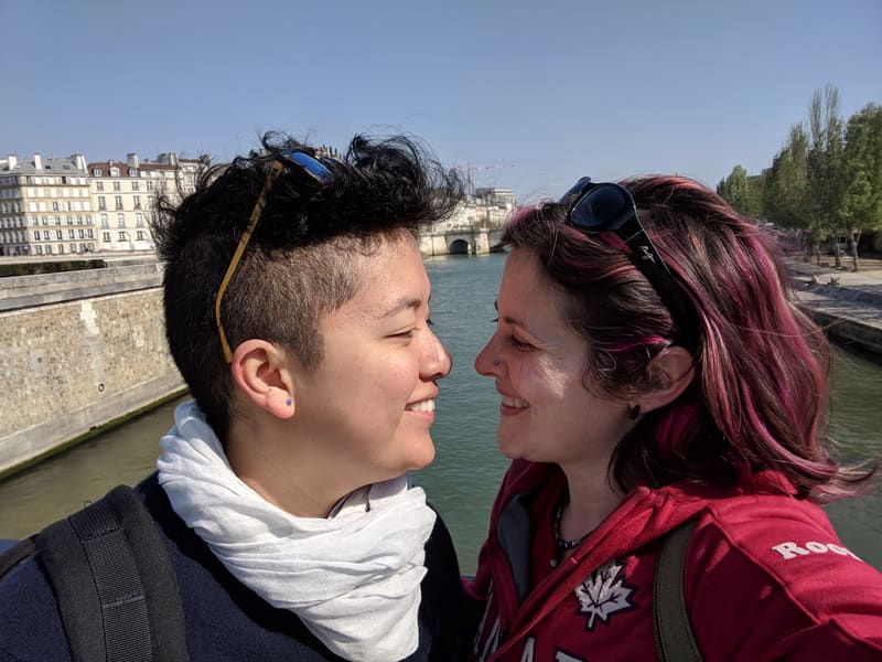 Holly and Rosalie cheek to cheek beside a river