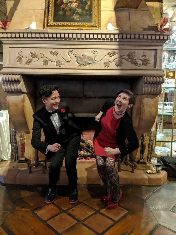 Holly and Rosalie dancing in front of an ornate fireplace