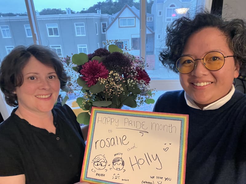 Holly and Rosalie holding a hand-drawn Happy Pride card
