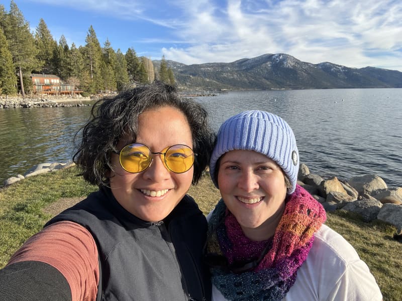 Holly and Rosalie in yellow glasses and a blue beanie by a lake