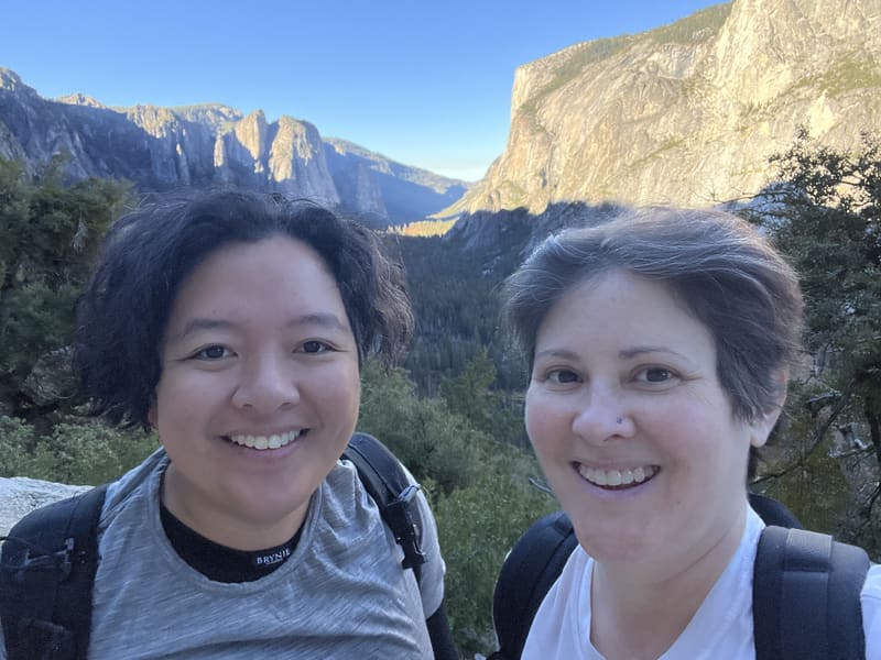 Holly and Rosalie in backpacks above a mountain valley